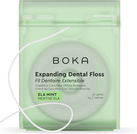 Boka Expanding Dental Floss in Ela Mint, front of the green dispenser labelled 27 yards, with a strand of floss looped outside