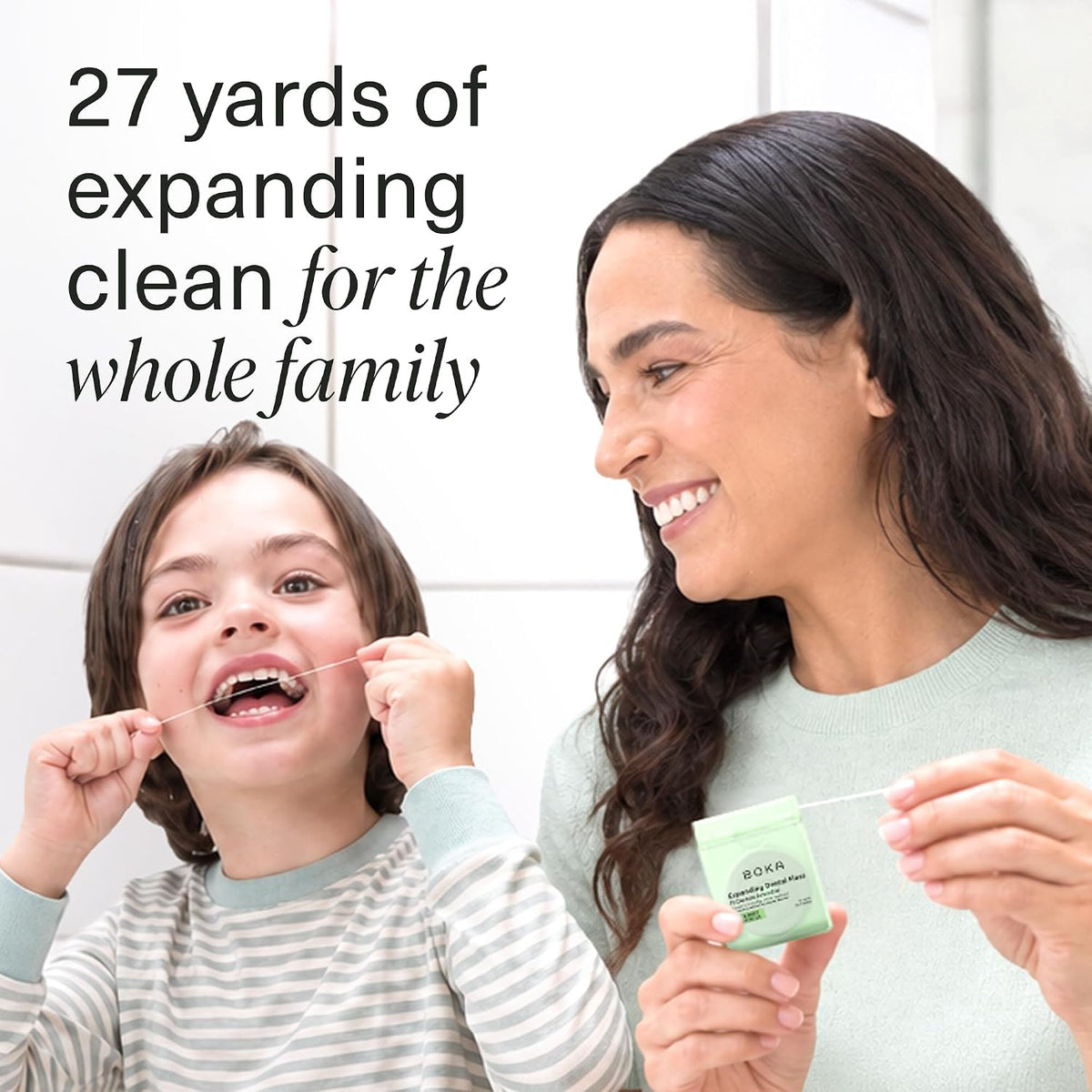 Parent and child flossing together, the parent holding the green dispenser